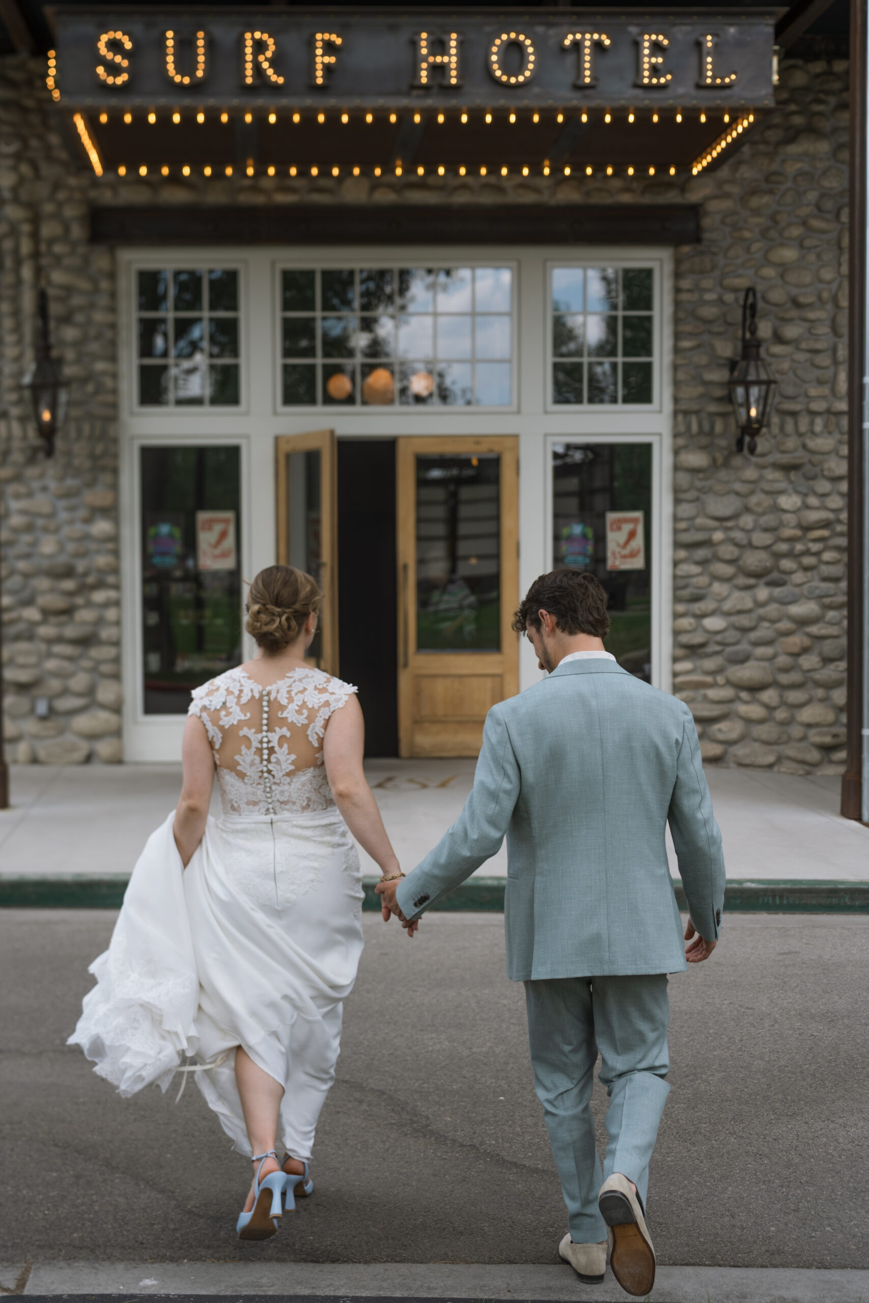 Couple walking in front of the Surf Hotel in Buena Vista on their wedding day.