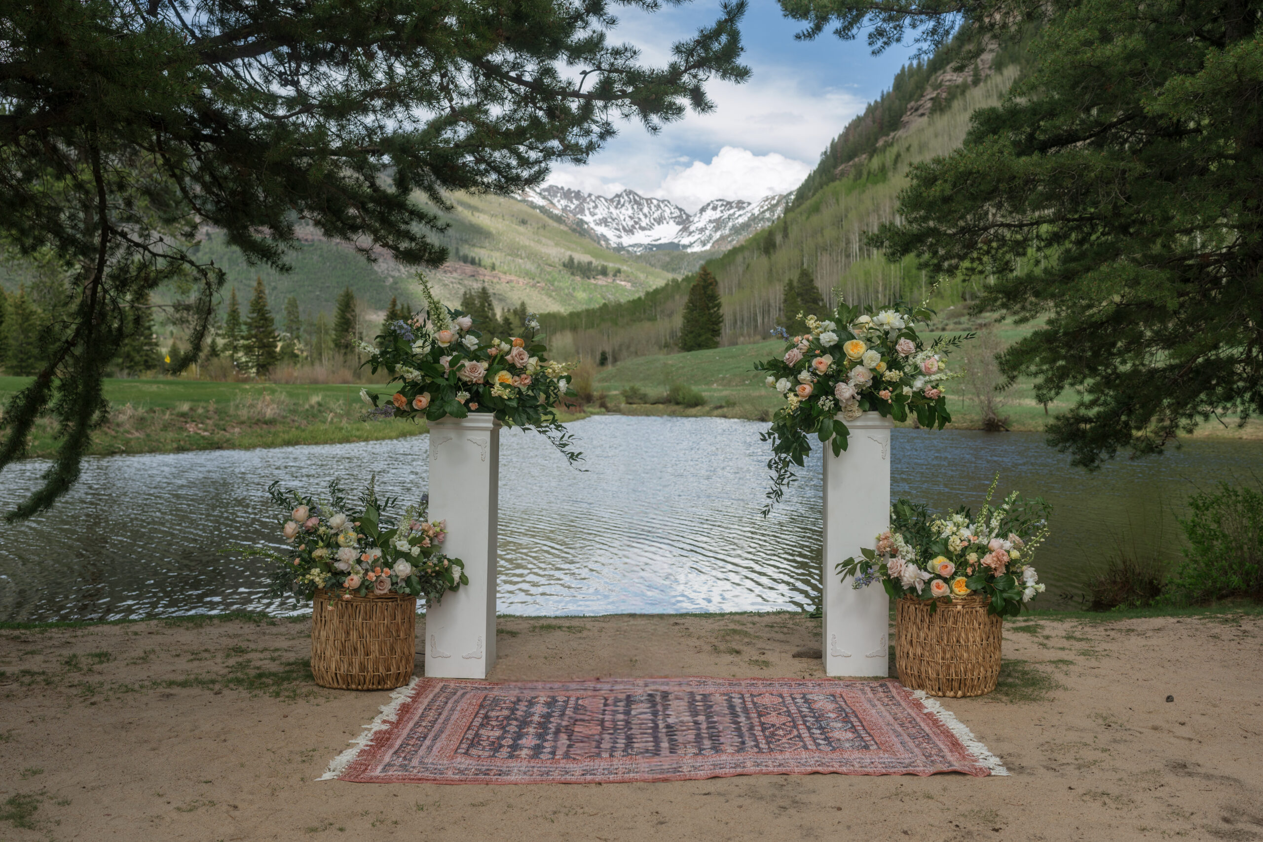 Floral arrangement for ceremony set up with lake and mountain backdrop in Vail.