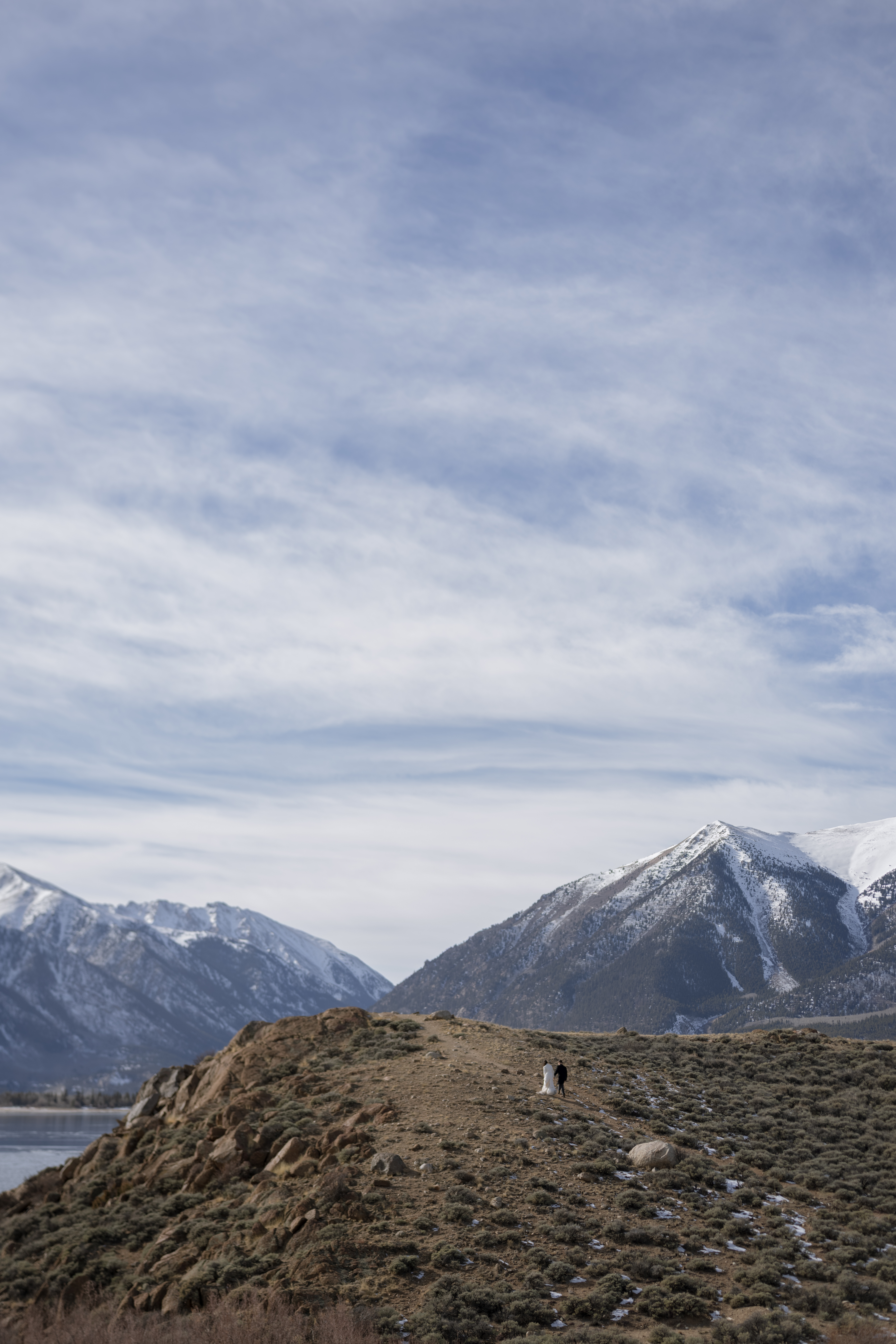 Couple walks up edge of shore at Twin Lakes on their elopement day.